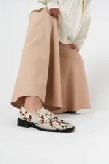 Mocasín de horma cuadrada en cuero de pelo vaca, con diseño enrejillado en la capellada.