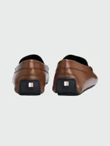 Mocasines de cuero color marrón claro con detalle de antifaz y logo grabado.