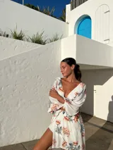 Vestido largo de crepé estampado en tonos verde y naranja, con escote en V, mangas largas abullonadas y abertura lateral en la falda.