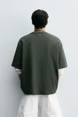 Remera verde oscuro de corte oversize, manga corta y cuello redondo.