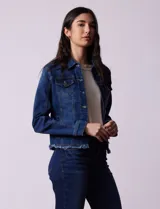 Campera de jean azul de la marca Baccini, con cuello solapa, abertura central con botones metálicos, bolsillos delanteros y ruedo desflecado.