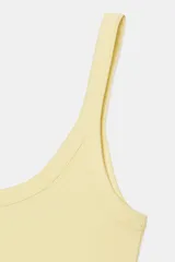 Camiseta sin mangas color amarillo pálido, de corte ajustado y cuello redondo.