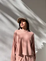 Conjunto deportivo color rosa compuesto por un buzo de cuello alto y mangas largas, y un pantalón palazzo con cintura elastizada y cordón ajustable.