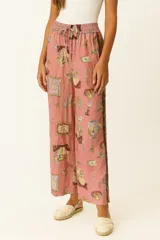 Pantalón de lino color rosado con estampado de objetos antiguos, corte ancho y tiro alto.