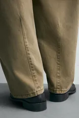 Pantalón de jean color verde oliva, corte balloon fit, con cinco bolsillos, efecto lavado y costuras giradas hacia adelante.