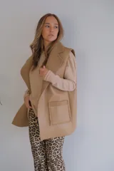 Chaleco largo color beige, con solapas y bolsillos delanteros con borde de corderito.