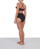 Top de bikini bandeau negro con breteles finos cruzados en la espalda y volados en los hombros.