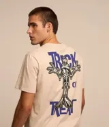 Remera de algodón color beige, de corte recto y manga corta. Estampa en la espalda con el personaje Pato Lucas disfrazado de esqueleto y la frase "Trick or Treat" en letras azules.