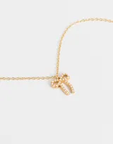 Cadena dorada con dije de moño con apliques de perlas.