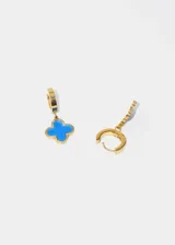 Aros dorados con dije en forma de trébol, elaborados en acero quirúrgico hipoalergénico.