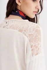 Remera negra de manga larga con detalle de encaje en hombros y espalda.