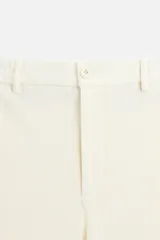 Pantalón color crudo de tejido con textura de rizo, corte relaxed fit, con cintura elástica, bolsillos frontales y traseros, cierre frontal con cremallera y botón.