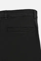 Pantalón cargo color verde oscuro, de corte relaxed fit, con bolsillos laterales con solapa y bolsillos traseros de vivo.