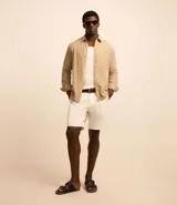 Camisa regular de lino color beige, con cuello inglés, manga larga y abotonadura frontal.