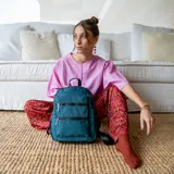Mochila color beige de tafeta con apertura superior con cierre y tiradores metálicos. Incluye bolsillos internos, bolsillo con doble cierre metálico al frente, asas rígidas de mano y correas regulables para colgar en la espalda.