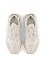 Championes New Balance color crema con detalles en beige y suela con diseño texturizado.