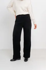 Pantalón negro de pana suave, de corte recto y tiro medio. Incluye cinturón extraíble del mismo género.
