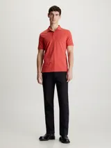 Chomba de piqué de algodón orgánico color ladrillo, corte slim, cuello clásico con dos botones, mangas cortas con puños de punto y logo bordado en el pecho.