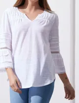 Blusa color celeste con escote en V, mangas largas acampanadas con detalle de crochet y frunces en los hombros.