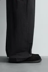 Zueco de cuero color negro con acabado serraje, plantilla acolchada, horma redonda y suela con volumen.