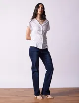 Remera blanca de lino, marca Zac & Rachel, con escote en V, abertura con botones y frunce en la parte delantera.