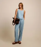 Musculosa de jeans celeste con recortes y cierre por botón.