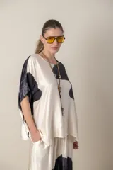 Blusa italiana color natural con estampado de hojas grandes en tonos marrones. Tiene cuello redondo y mangas cortas amplias.