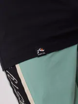 Remera negra de algodón con estampado en la espalda que incluye un sol estilizado, texto con la marca "Rusty" y la frase "Golden Sun - Endless Waves".