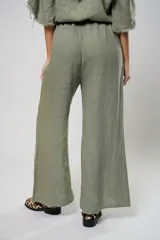 Pantalón verde oliva de lino, corte palazzo, con cintura elástica y aberturas laterales con botones.