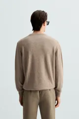 Jersey de hombre regular fit, color negro, tejido en hilatura de lana cashmere. Cuello redondo y manga larga con terminaciones en rib.