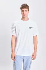 Camiseta blanca de corte oversize con estampa en la espalda con la frase "DJ Creates Vibes" y un disco de vinilo.