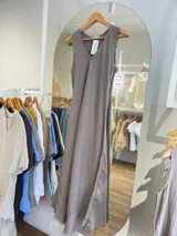 Vestido largo confeccionado en 100% lino, de diseño sin mangas con escote en V y detalles desflecados en sisas y ruedo. Presenta un corte holgado y fluido ideal para el verano.