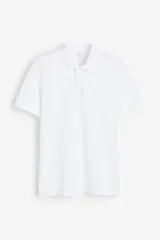 Remera polo blanca de piqué de algodón, de manga corta con cuello clásico, tapeta de botones y corte estándar.