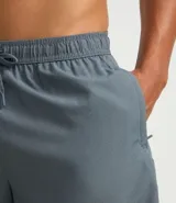 Bermuda deportiva masculina color gris oscuro, confeccionada en poliéster con textura perforada y cintura ajustable con lazo.