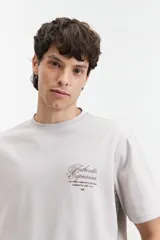 Remera de manga corta color verde claro con estampado de texto en el pecho, de corte oversize y cuello redondo.