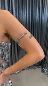 Brazalete plateado para el brazo con diseño de hojas.