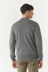 Campera tejida color ladrillo con cierre frontal, cuello alto y bolsillos laterales.