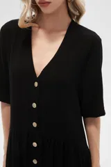 Vestido corto color crema, de corte holgado, con cuello en V y botones frontales.