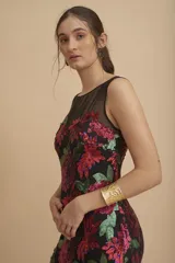 Vestido largo de fiesta color negro, con escote redondo y bordado de lentejuelas formando flores rojas y verdes.