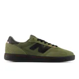 Championes New Balance modelo 440, color verde oliva con detalles en negro y naranja, confeccionados en gamuza y malla, con logo "N" característico en los laterales y suela de goma negra.