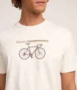 Remera color crudo de algodón, de cuello redondo y manga corta. Presenta un estampado con una bicicleta de carreras y la palabra "Racing".