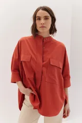 Sobrecamisa celeste de corte recto, con cuello mao, mangas 3/4 con puños y cierre frontal con botones. Tiene dos bolsillos de parche en el pecho.