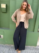 Pantalón negro de seda opaca, corte palazzo, tiro medio alto y cintura elástica con cordón ajustable.