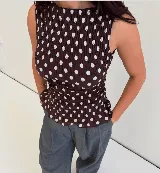 Top sin mangas con cuello redondo y diseño ajustado con frunces elásticos a cuadros rojos y blancos.