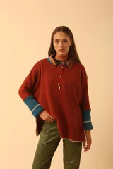 Buzo de lana en color naranja con detalles en azul, de corte amplio y diseño cómodo.