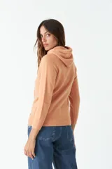 Sweater rojo tejido de punto con capucha y cordones ajustables.