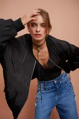 Campera negra estilo aviadora con bolsillos con cierre metalizado y forro naranja.