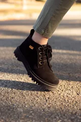 Bota de cuero color negro, con cordones y suela track.