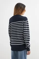 Sweater de algodón a rayas horizontales blancas y azul marino, con cuello redondo y botones decorativos en el hombro.