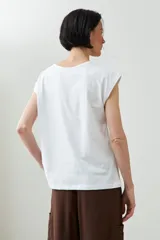 Remera de manga corta color verde agua con bordado floral blanco en la zona del pecho y cuello con abertura en forma de lágrima.